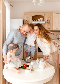 Family preparing food on table at home