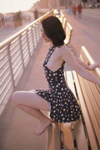 Side view of woman sitting on bench