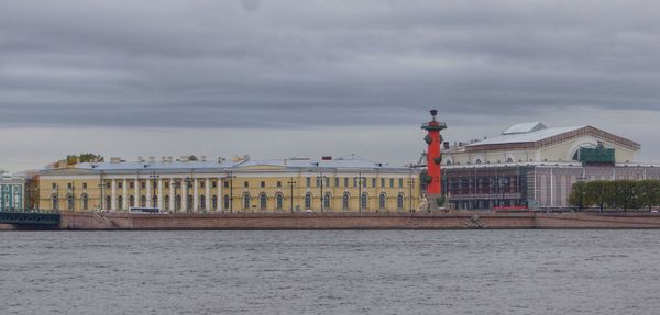 View of building by sea against cloudy sky