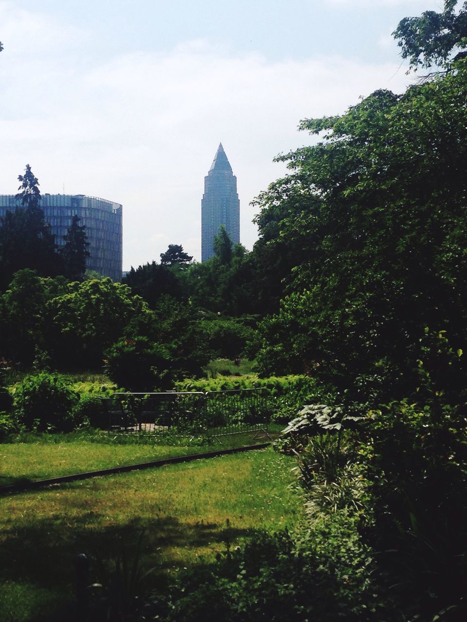 tree, architecture, built structure, building exterior, sky, growth, green color, cloud - sky, famous place, travel destinations, grass, park - man made space, tower, city, travel, day, history, incidental people, tall - high, tourism