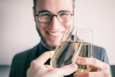 Close-up of smiling young man holding drink