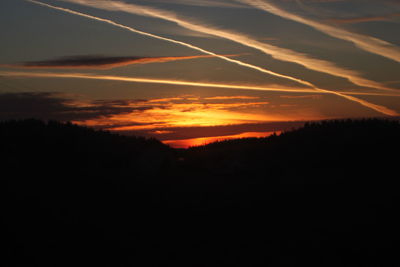 Scenic view of silhouette landscape against orange sky