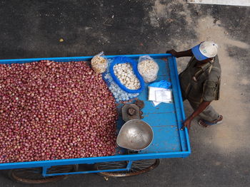 High angle view of vendor pushing cart with onions on road