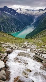 Scenic view of river by mountains against sky