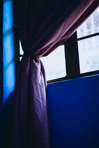 Close-up of person standing by window at home