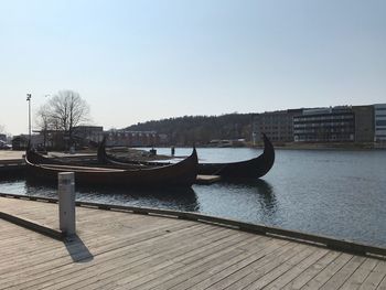 Boats moored in river against clear sky