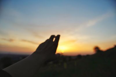 Midsection of silhouette person against sky during sunset