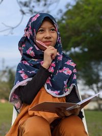 Portrait of a smiling young woman while thinking something