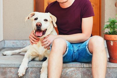 Portrait of woman with dog sitting at home