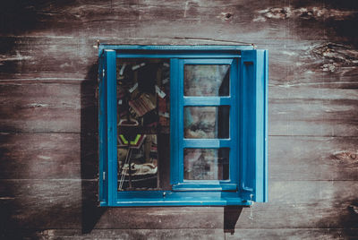 Blue open window in log cabin