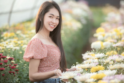 Portrait of smiling young woman with red flower