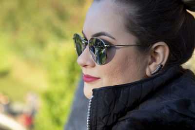 Portrait of young woman looking away outdoors