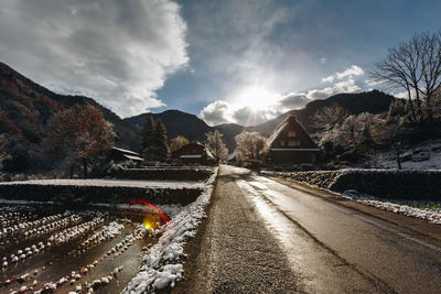 Road by mountains against sky