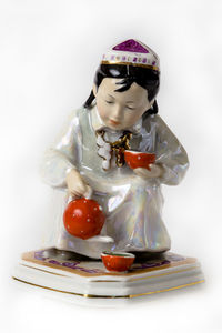 Close-up of figurine on table against white background