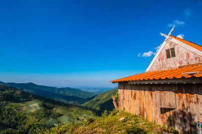 Panoramic view of building and mountains against blue sky