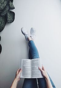 Low section of person reading book against white background