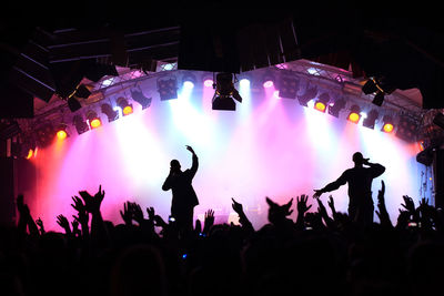 Singers performing on stage by people during concert