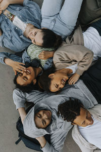 High angle view of smiling teenagers lying together and at each others