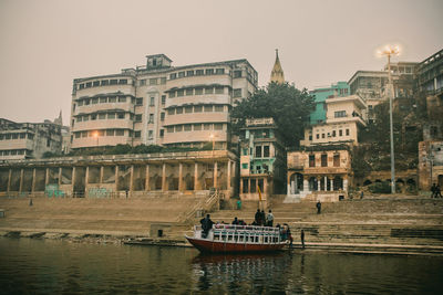 Boats in river with buildings in background