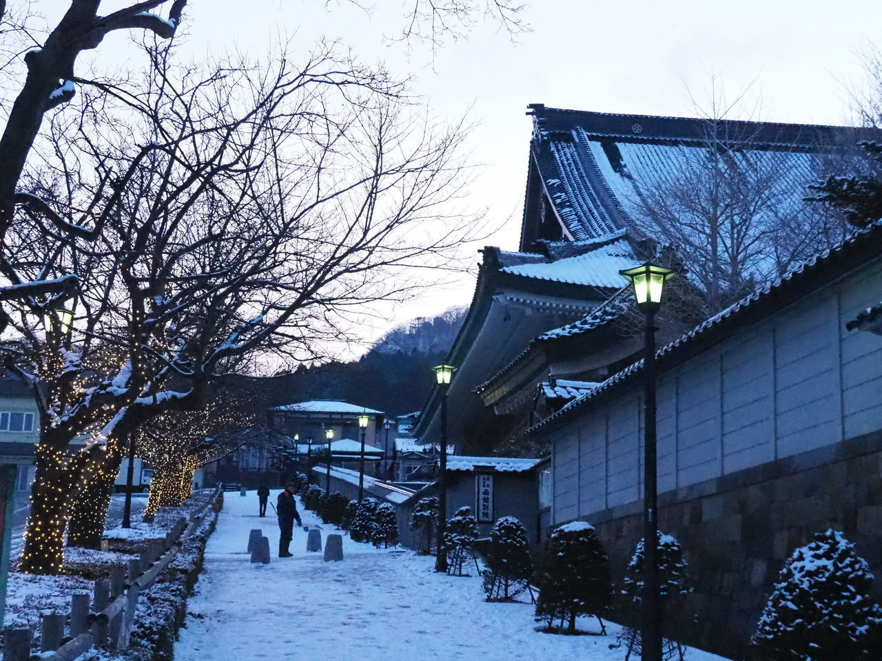 SNOW COVERED HOUSES BY BUILDING AGAINST SKY