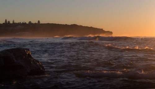 Scenic view of sea against clear sky during sunset