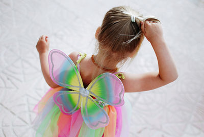 Rear view of little blondie girl in butterfly costume 