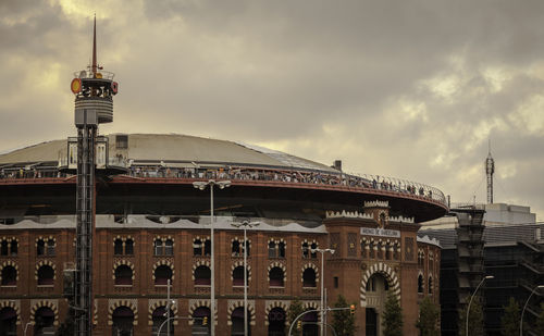 View of buildings in city against cloudy sky