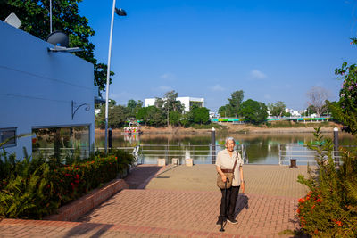 Senior woman at the ronda del sinu walking path along the river bank in montería, colombia.