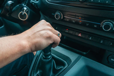 Cropped hand of man holding steering wheel