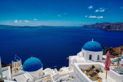 Panoramic view of sea and buildings against blue sky