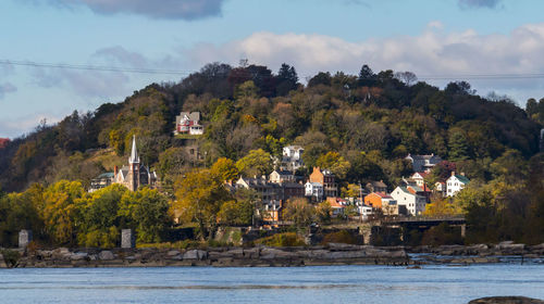 Town by sea and mountains against sky