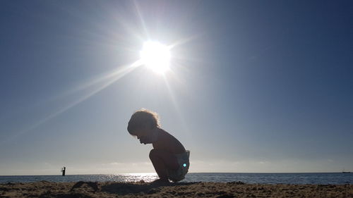 Woman on beach against sky on sunny day