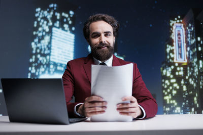 Young man using laptop while sitting on table