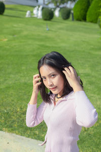 Portrait of young woman standing on field