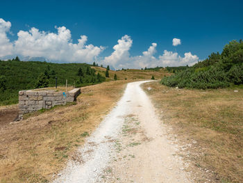 Gravel road to hill peak. dusty mountain road in dolomite alps. enjoy trekking and mountaineering.