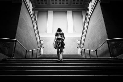 Rear view of woman standing on stairs