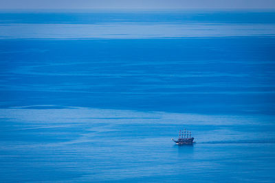 A luxury sailing ship navigates the open sea against the background of blue sky 