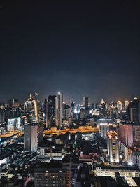 Illuminated cityscape against sky at night