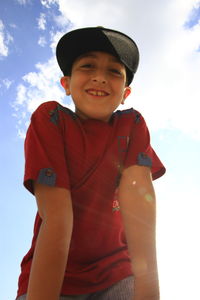 Portrait of smiling boy standing against sky