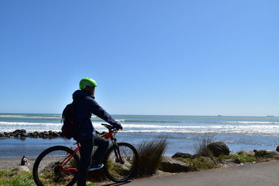 Man riding bicycle by beach