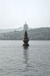 Boat in lake by building against sky