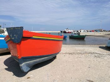 Boats moored at harbor against sky