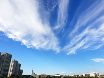 Low angle view of buildings against cloudy sky