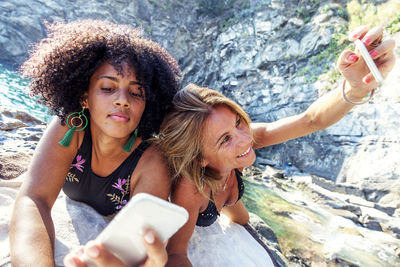 Portrait of smiling young woman using mobile phone