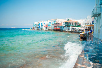 Scenic view of sea against buildings in city