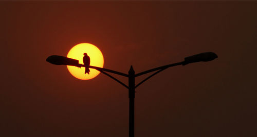 Low angle view of street light against orange sky