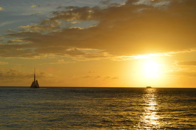 Sailboat sailing on sea against sky during sunset