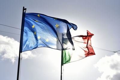 Low angle view of flags against sky