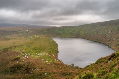 Lake, lough bray with mountain trail on the left and cliffs on right in wicklow mountains