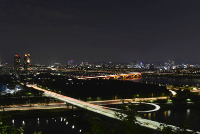 High angle view of illuminated bridge and buildings at night